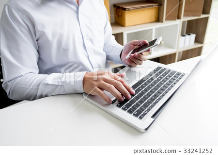 Man holding credit card in hand and entering security code using Man holding credit card in hand and entering security code using 33241252