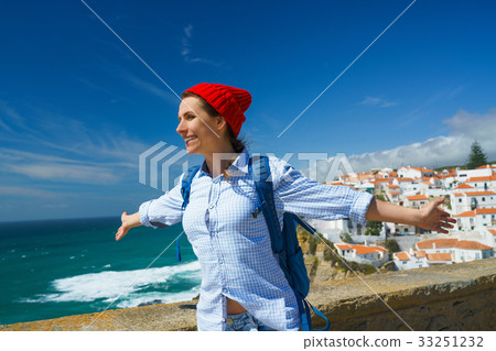Woman with a backpack is spinning her arms out 33251232