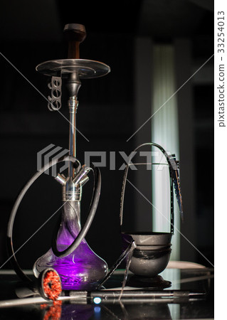 The purple hookah is placed on a table. 33254013