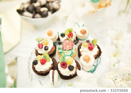 Delicious and tasty dessert table with cupcakes 33255698