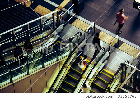 People riding escalators People riding escalators 33259763