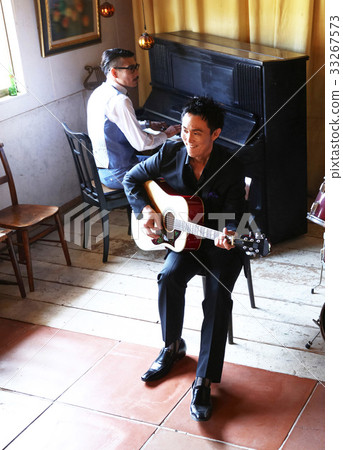 Men playing an instrument 33267573