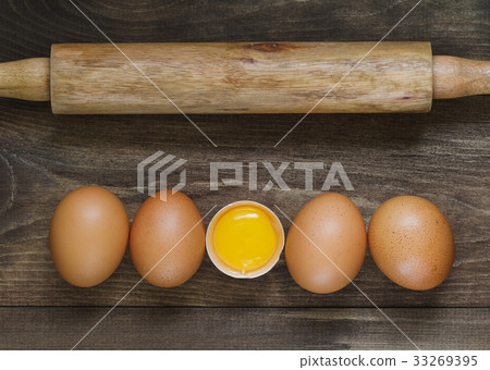 Top view on fresh eggs in a row and rolling pin on Top view on fresh eggs in a row and rolling pin on 33269395