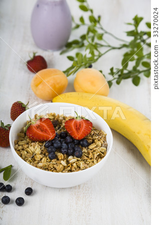 Granola with fruits on a wooden table.  33270024