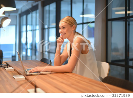Business blonde girl using a laptop in an office 33271989