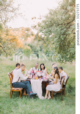 The smiling guests and newlyweds are celebrating 33273775