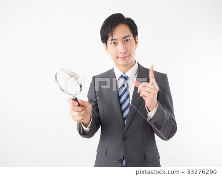 A business man with a loupe 33276290