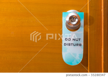 Do Not Disturb Sign Tag Hanging On Metal Door Knob Stock Photo