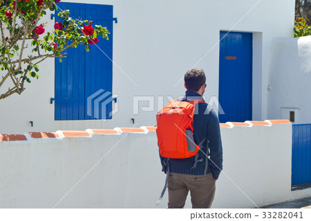 Traveler with a red backpack near beauty house Traveler with a red backpack near beauty house 33282041