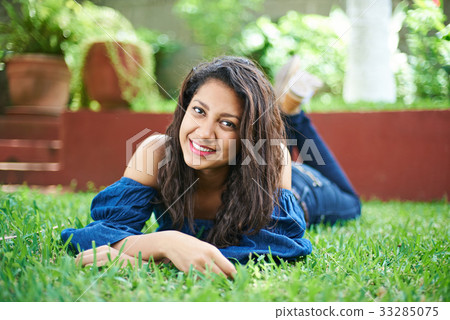 teenager laying on grass 33285075