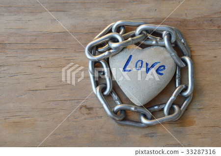 chain roll heart stone on wooden board 33287316