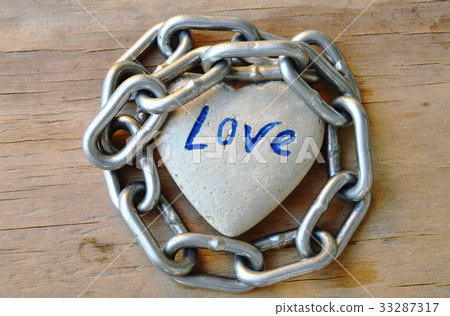 chain roll heart stone on wooden board 33287317