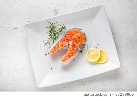 Salmon. Raw salmon steak with rosemary and lemon. Salmon. Raw salmon steak with rosemary and lemon. 33289009