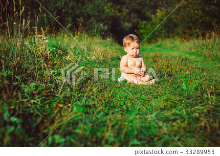 The child is sitting on the grass The child is sitting on the grass 33289953