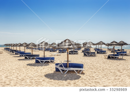 Beach zone for sunbathing with umbrellas and sun Beach zone for sunbathing with umbrellas and sun 33298989