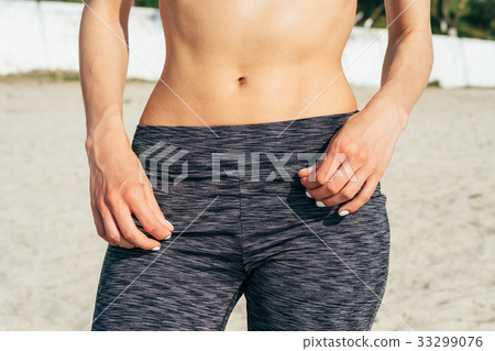 Close-up flat women's belly on the beach Close-up flat women's belly on the beach 33299076