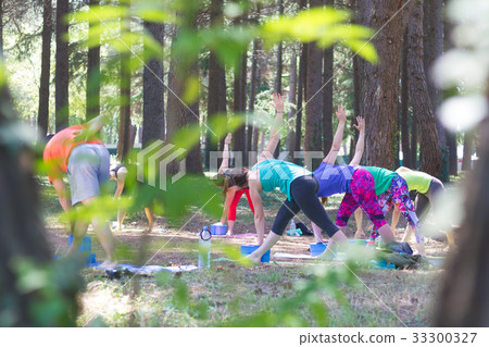 Group of young people practising yoga outdoors. 33300327