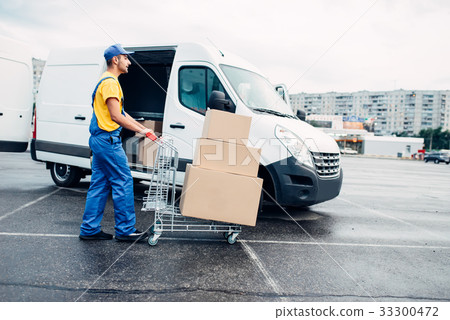 Courier with parcel trolley against logistic truck Courier with parcel trolley against logistic truck 33300472