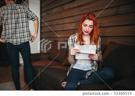 Woman reads letter and crying, couple in conflict Woman reads letter and crying, couple in conflict 33300555