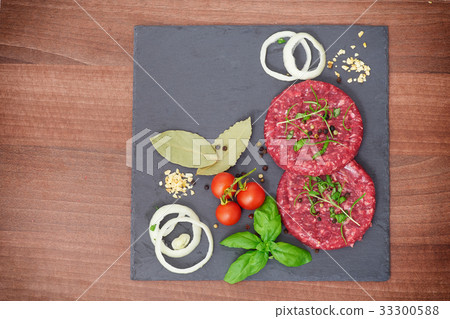 Raw burgers on dark slate board Raw burgers on dark slate board 33300588