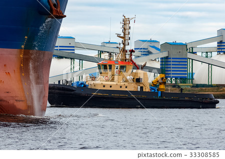 Tug ship towing blue bulk carrier Tug ship towing blue bulk carrier 33308585