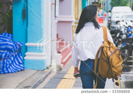 Back of woman traveler walking on street in city 33308808