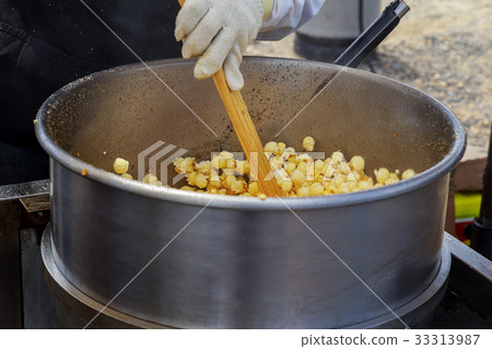 Making popcorn in the small kiosk. 33313987
