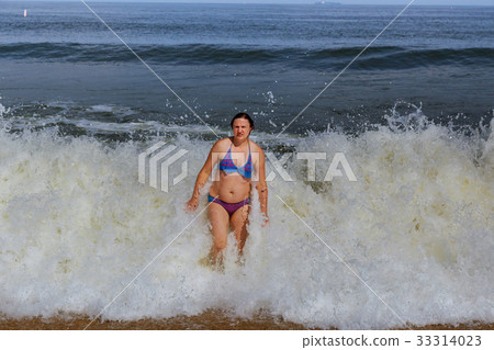 young woman running in the water 33314023