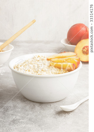 Oatmeal with nectarine, honey on a gray background Oatmeal with nectarine, honey on a gray background 33314176