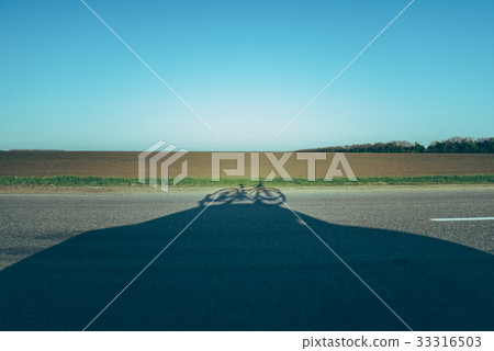 road with shadow of the car with bicycle on the road with shadow of the car with bicycle on the 33316503
