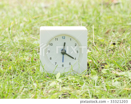 Square simple white clock on the grass 12:20 Square simple white clock on the grass 12:20 33321203