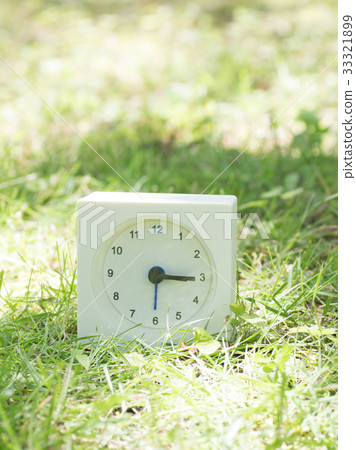 方形簡單的白色時鐘在草地上3:15 33321899
