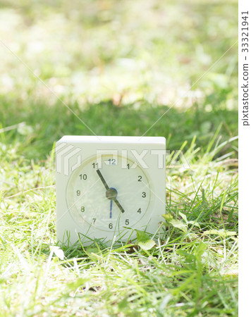 Square simple white clock on the grass 4:55 33321941