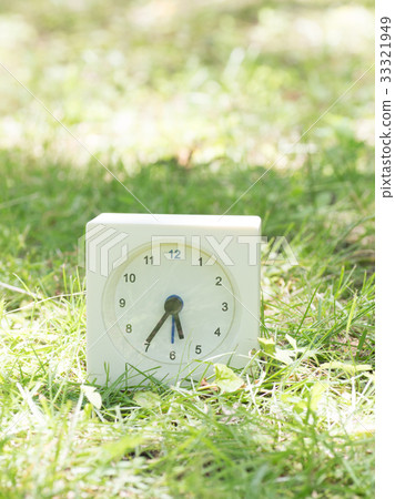 Square simple white clock on the grass 5:35 33321949