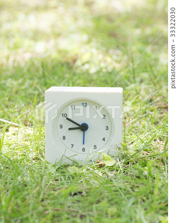 Square simple white clock on the grass 8:50 33322030