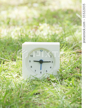 Square simple white clock on the grass 9:15 33322035