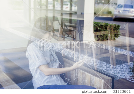 Businesswomen with casual suit using the smart phone in the coffee shop,shooting from out of windows, business technology concept Businesswomen with casual suit using the smart phone in the coffee shop,shooting from out of windows, business technology concept 33323601