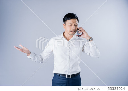 a man is talking on mobile phone with a scowl on his face a man is talking on mobile phone with a scowl on his face 33323924