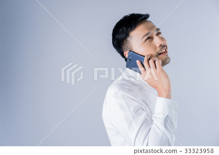 a businessman is talking on a phone and smiling a businessman is talking on a phone and smiling 33323958