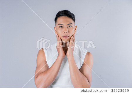 a man is touching his face on gray background a man is touching his face on gray background 33323959