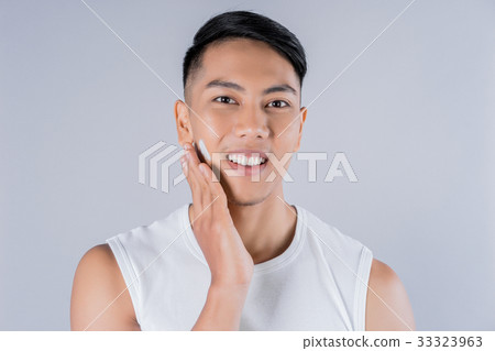 a man is applying shaving cream on his face and smiling 33323963
