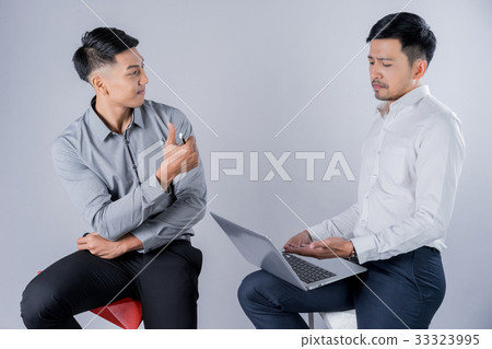 two business men are sitting and discussing something together 33323995