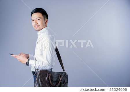 a photo of a happy businessman using mobile phone on gray background a photo of a happy businessman using mobile phone on gray background 33324006