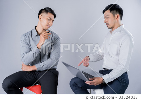 two businessmen are sitting and discussing something on laptop two businessmen are sitting and discussing something on laptop 33324015