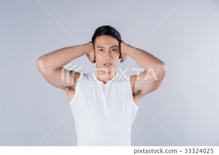 a fitness model is standing with hands behind his head 33324025