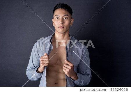 young body builder is posing with shirt on black background young body builder is posing with shirt on black background 33324026