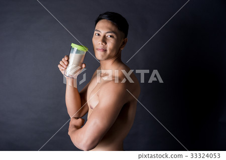 Asian man is holding a protein shake on black background Asian man is holding a protein shake on black background 33324053