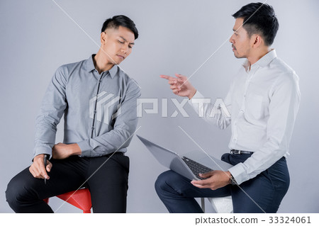 Two business men are working on laptop in their office 33324061