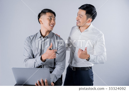 two businessmen are talking and showing thumbs up sign two businessmen are talking and showing thumbs up sign 33324092