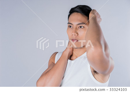 a young man is touching his face on gray background 33324103